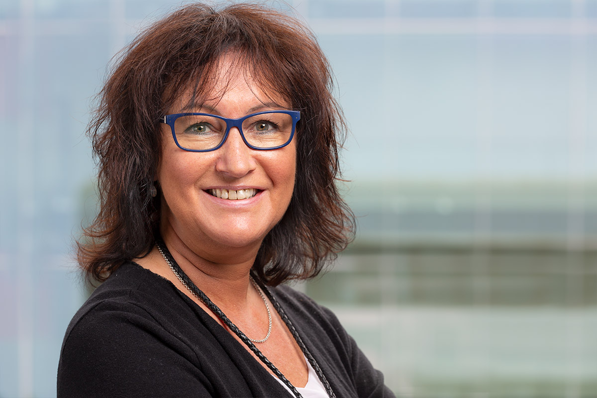 Porträt von Birgit Strombach, Kauffrau der Grundstücks- und Wohnungswirtschaft bei Stegmeier & Weber Immobilien GmbH, mit Brille und freundlichem Ausdruck vor neutralem Hintergrund.